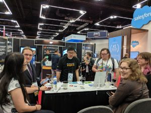 Photo of a six people at the Expo Hall at OSCON. One of them is wearing a suit.