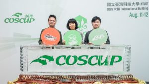 A photo of three people, holding signs reading "GNOME Asia," "openSUSE," and "COSCUP."