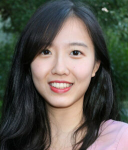 A photo of a person with long hair and a pink shirt.